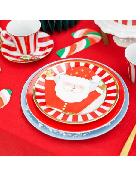 Assiette décorative de Noël avec Papa Noël sur fond rouge et assiettes festives, décor candy cane et vaisselle assortie.