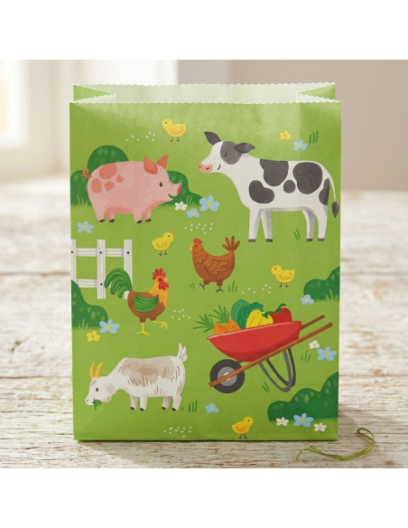 Sacs cadeaux animaux de la ferme sur fond vert avec poule, cochon, vache, chèvre et brouette de légumes.