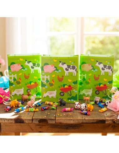 Sacs cadeaux animaux de la ferme verts décorés de vaches et poules, avec bonbons colorés et figurines autour sur une table en bo